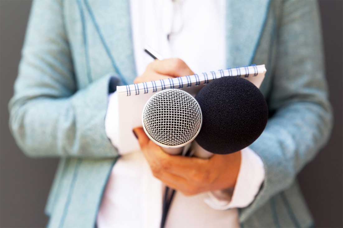  Journaliste écrivant des notes et tenant des microphones